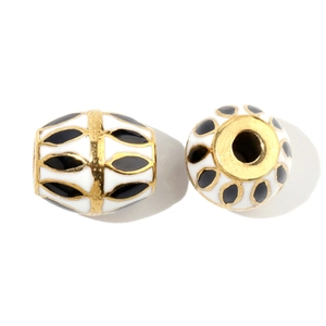 Close-up of DIY jewelry beads with black leaf patterns and gold accents on white base