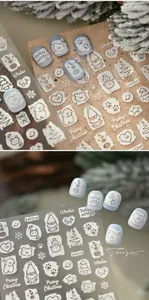 Detailed macro view of 5D embossed Christmas nail stickers with snowman and tree patterns
