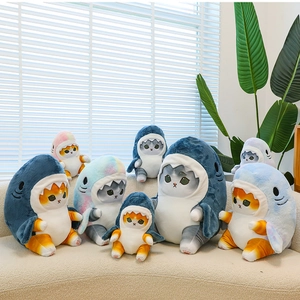 Shark cat plush toys in various sizes and colors displayed on a beige sofa