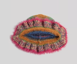 Detail of colorful knit bucket hat with vibrant stripes and pink faux fur brim texture