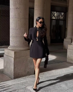 Detail of black long-sleeve dress featuring cutout design and jewel buttons in street style