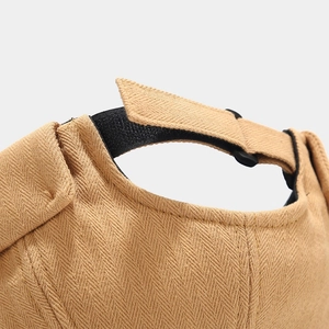 Macro view of adjustable rear buckle and herringbone fabric on the khaki docker cap