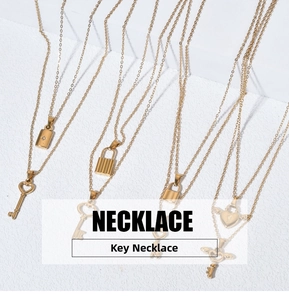 Détails de colliers double couche dorés avec pendentifs clé et cadenas sur pierre