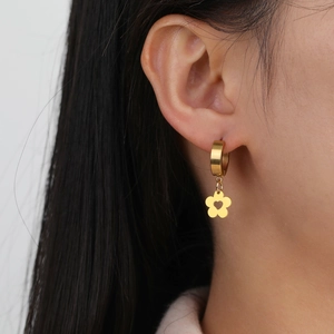 Close-up of gold stainless steel hoop earring with hollow heart flower pendant