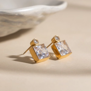 Makro-Detail des quadratischen 18K Gold Zirkonia Ohrsteckers mit edlen Kristallfacetten