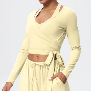 Detail of waist-tie wrap yoga top and drawstring wide-leg pants in soft yellow fabric