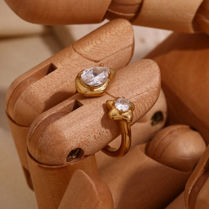Macro shot of gold-plated open ring with teardrop and star-shaped zircon stones