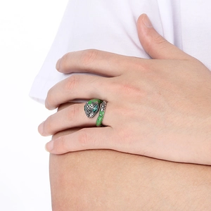 Detail of snake ring with green enamel scales and crystal eyes on a finger