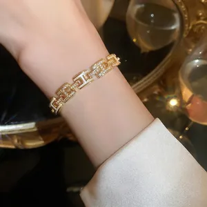 Élégant bracelet doré à maillons H avec émail blanc et accents de zircon étincelants