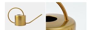 Close-up of golden stainless steel watering can showing long spout and polished finish