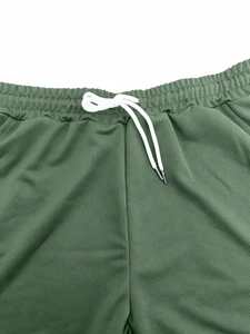Détail d'un short de sport vert forêt en tissu respirant avec cordon de serrage blanc