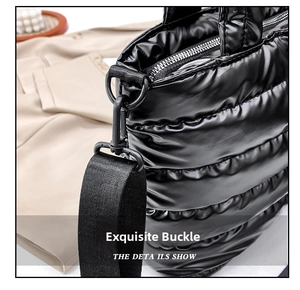 Detail of black quilted tote bag showing matte black hardware and nylon shoulder strap