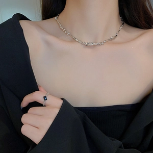 Dettaglio della collana stile metallo liquido con texture irregolare indossata dalla modella
