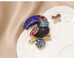 Detailed macro shot of a vintage toucan bird brooch with colorful rhinestone inlay
