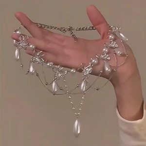 Vue détaillée du collier à franges argenté multicouche avec perles et breloques papillon