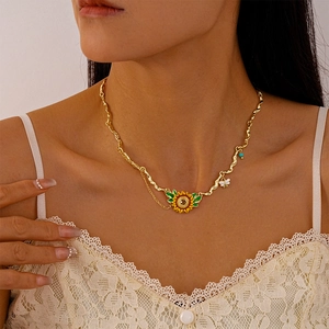 Detail of sunflower and bee pendant on a golden wavy chain worn by a model