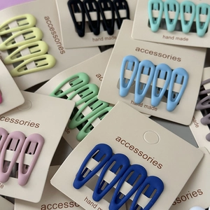 Close-up of matte star hair clips in assorted colors on cardboard packaging displays