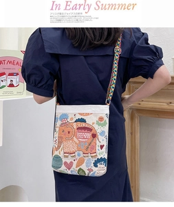 Close-up of colorful ethnic elephant embroidery on beige canvas crossbody bag strap