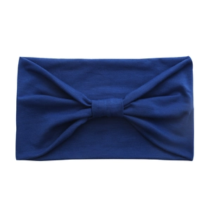 Detail of blue wide cotton yoga headband showing a soft knot and ribbed fabric texture
