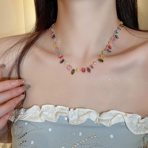Close-up of elegant multicolor zircon geometric necklace worn by a fashion model