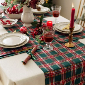 Festive Christmas table runner with red and green plaid pattern in a holiday setting
