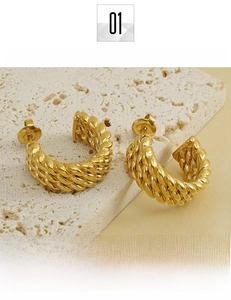 Close-up of 18k gold plated titanium steel C-shape twisted hoop earrings on stone