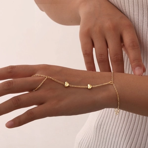 Detail of 18K gold-plated double-layer slave bracelet with heart charms on hand
