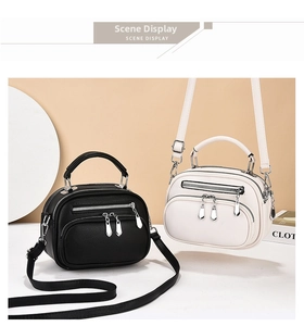 Close-up of dual-color crossbody bags with multi-layer zippers and lychee grain leather