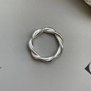 Macro shot of silver twisted Mobius knot ring featuring detailed striped texture