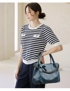 Detail view of navy blue lychee texture tote bag with chain and bow knot on strap