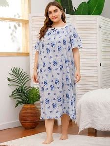Detail of floral plus size nightgown showing lace neckline and bow on light blue fabric