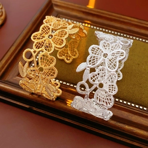 Detailansicht der hohlen floralen Manschettenarmbänder in Gold und Silber mit Webstruktur