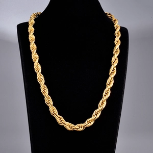 Macro view of thick gold-plated rope chain texture on a black display stand