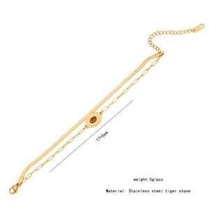 Detail view of golden double-layer stainless steel bracelet with oval tiger eye stone