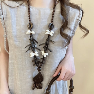 Detail of bohemian necklace with coconut shell hearts, wood beads, and white flowers