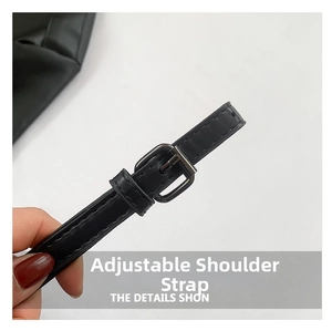 Detail shot of the black textured leather adjustable shoulder strap with metal buckle