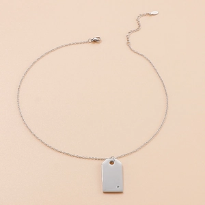 Macro shot of silver rectangular pendant with small diamond and S925 hallmark tag
