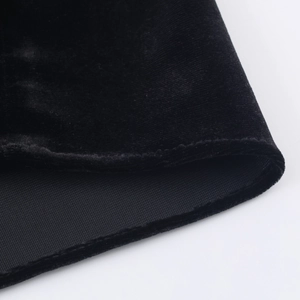 Dettaglio dell'orlo del vestito in velluto nero con texture del tessuto e cuciture rifinite
