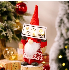Close-up of a lit LED Christmas gnome with a 'HO HO HO!' sign and knitted fabric details