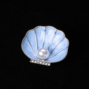 Detailed view of enamel shell brooch with white pearl and sparkling rhinestones