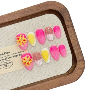 Pink press-on nails featuring 3D floral carvings, lemon patterns, and pearl accents