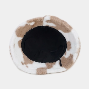 Detail of adjustable strap and black fabric lining inside a cow print faux fur bucket hat