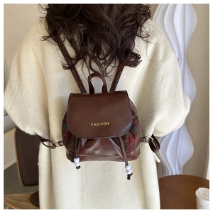 Detail eines Vintage Mini-Rucksacks mit Karomuster Ledertextur und Kordelzug