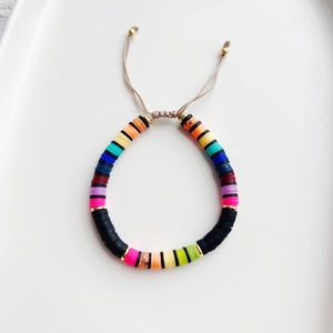 Detail of colorful heishi bead bracelet with adjustable beige cord and gold accents