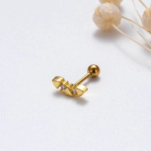 Detail of gold screw back stud earring with tiny triangle zircon inlays on textured white base