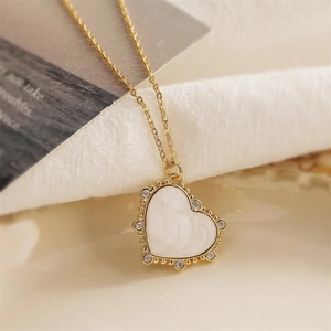 Golden heart pendant necklace with white inlay and sparkling cubic zirconia stones