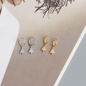 Close-up of gold and silver Christmas tree earrings with pavé zircon stones