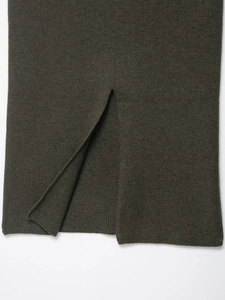Gros plan détaillé d'une jupe en maille vert olive foncé avec une fente latérale chic