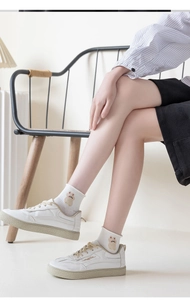 Close-up of white cotton socks with cartoon animal embroidery worn with canvas shoes