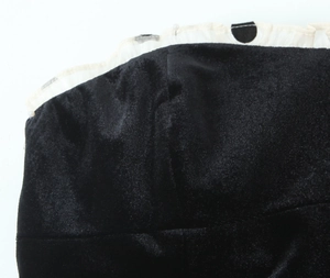 Gros plan sur le tissu en velours noir avec bordure à volants à pois blancs
